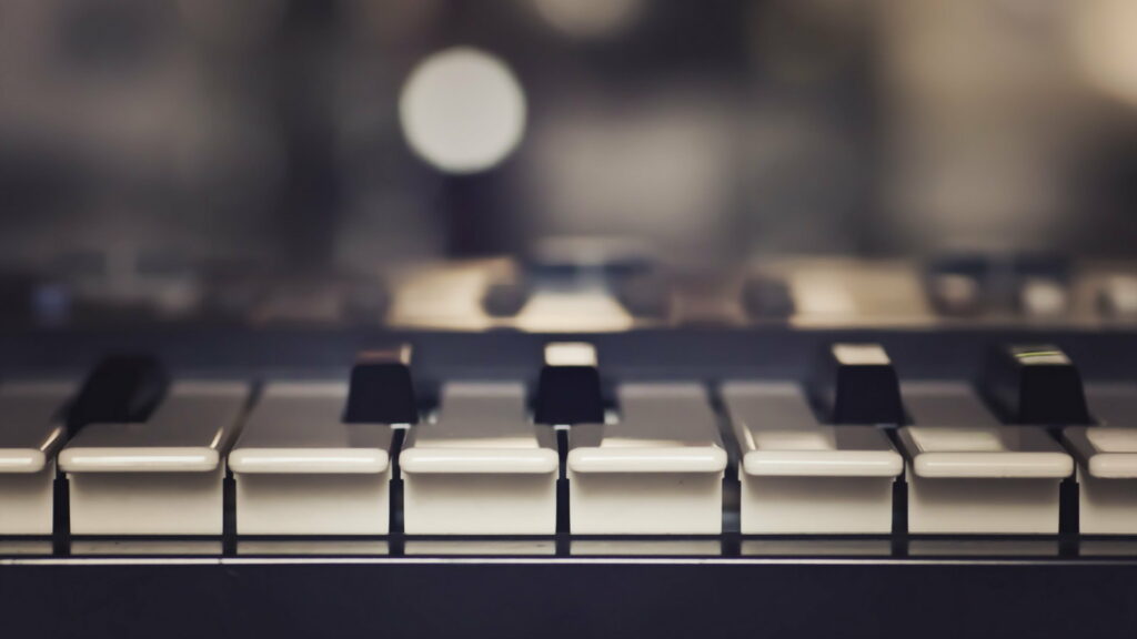 Close-up of piano keys with soft bokeh lighting creating a moody melodic atmosphere wallpaper