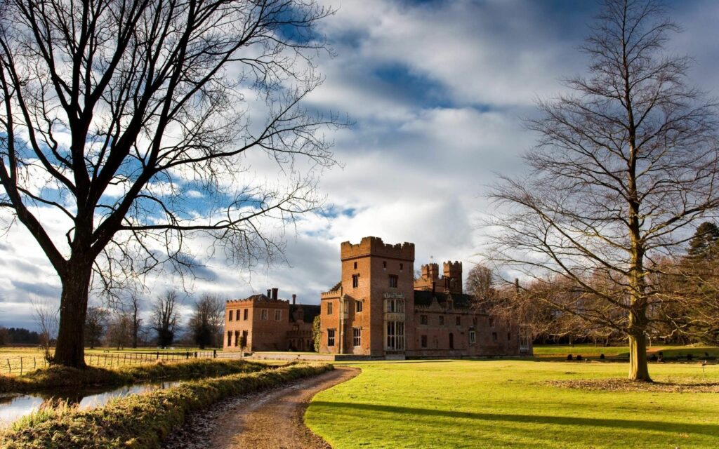 Picturesque Castle Wallpaper: Serene Countryside & Blue Sky Background