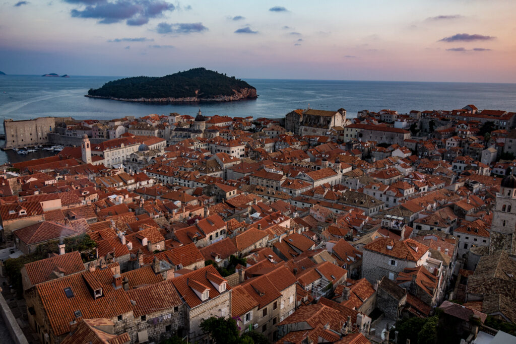 Charming Coastal City Wallpaper: Red Roofs & Serene Sunset View