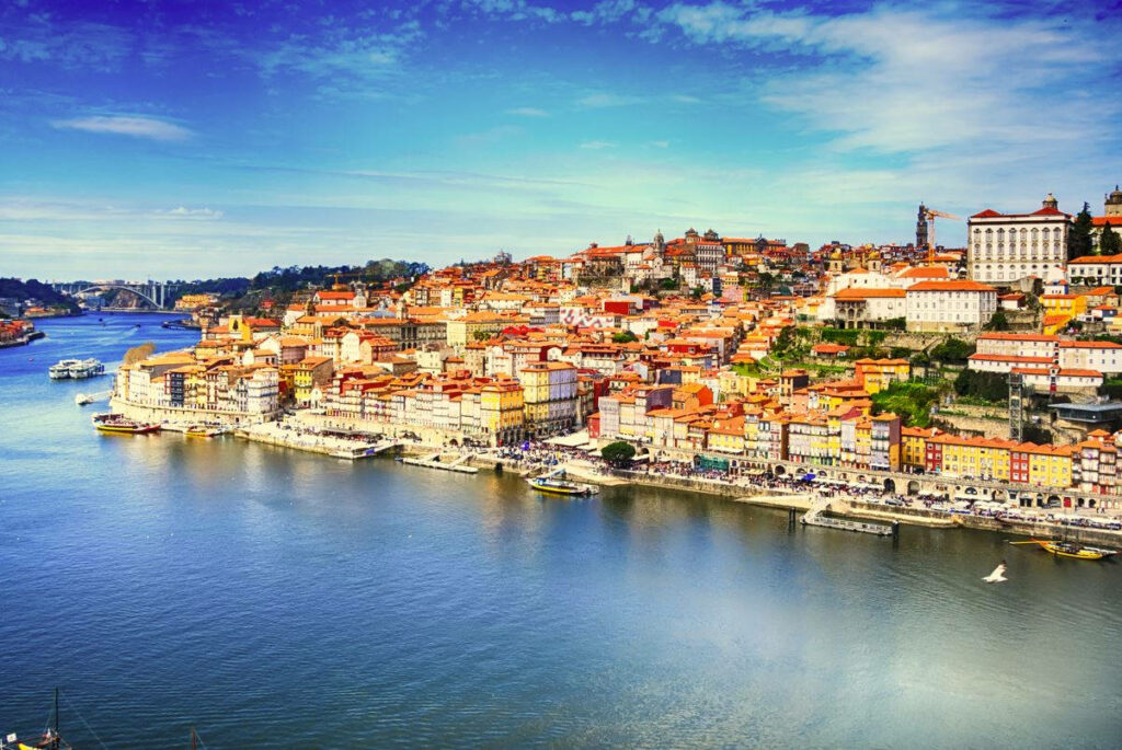 Scenic Lisbon Coastal View: Colorful Buildings & Clear Blue Sky Wallpaper