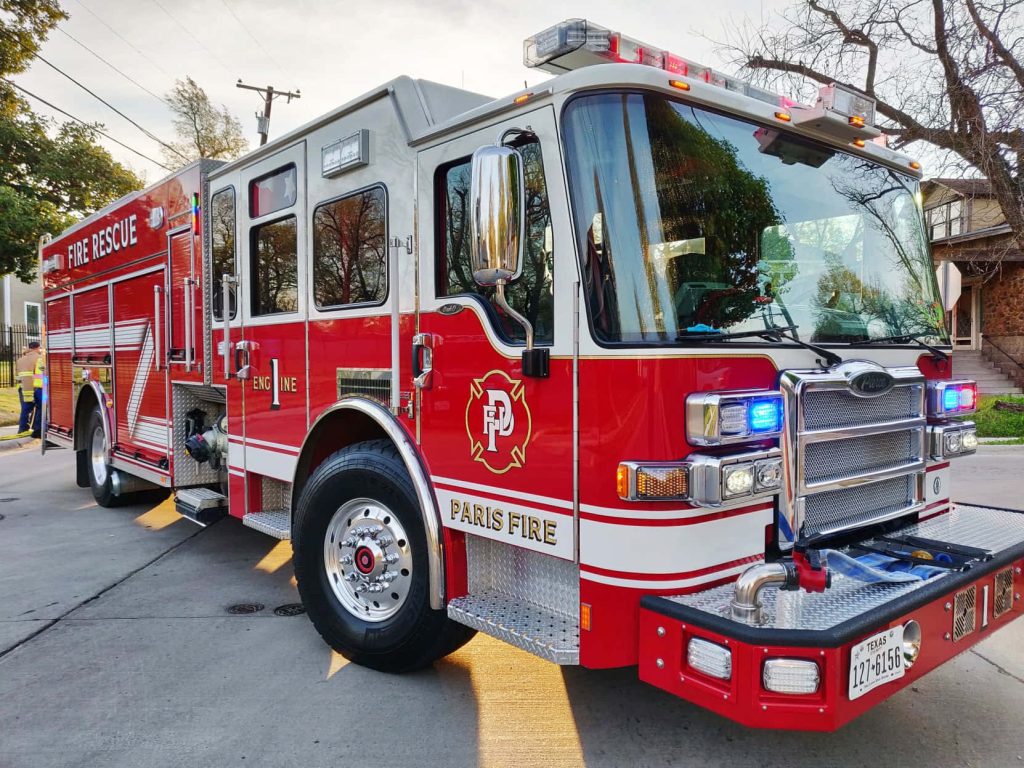 Low-angle front view of red white Pierce fire engine Paris Fire Department Texas in daylight Wallpaper