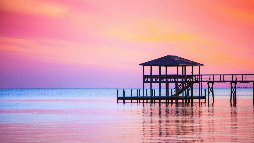 Serene Twilight: Captivating Pink Sunset reflects over a quaint waterfront pier Wallpaper
