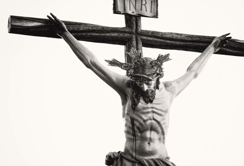 Gripping Monochrome Sculpture: Jesus' Agony Pictured on the Cross amidst Sculptural Serenity Wallpaper