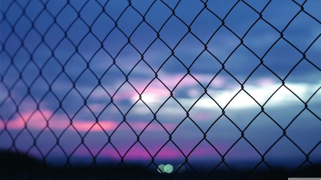 Pink Perfection - A Simple Metal Fence Against a Blurry Sky Wallpaper