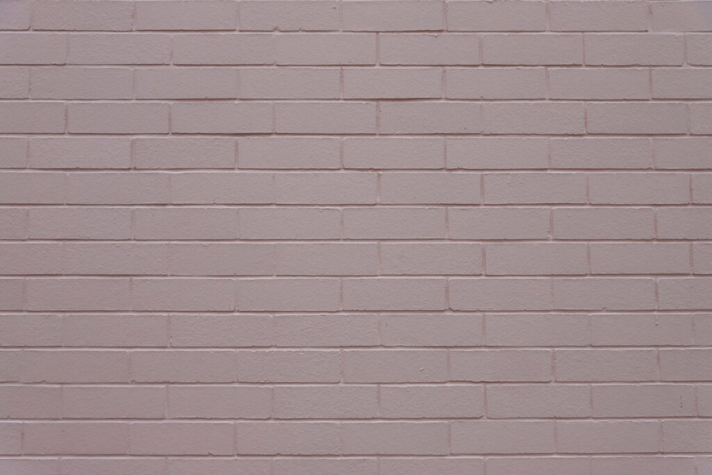 Rosy Hues on Textured Brick: Captivating 5K Wallpaper Background