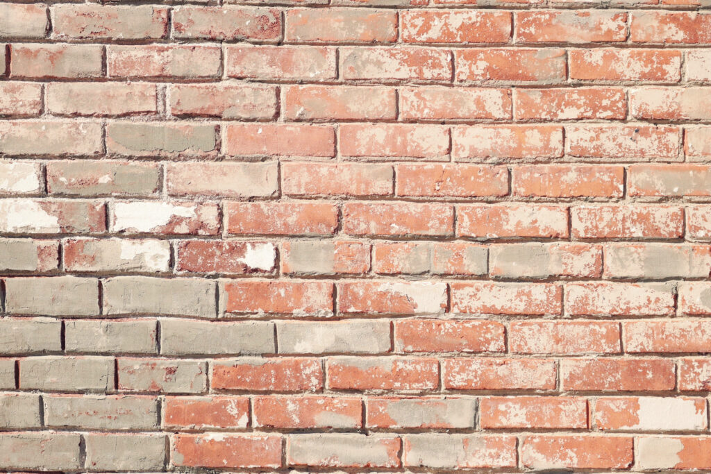 Weathered brick wall wallpaper with rustic terracotta red pale gray distressed off-white tones