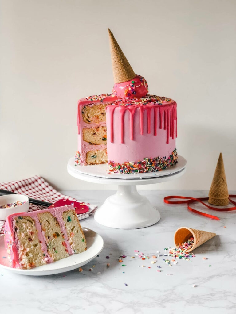 Pink ice cream cake wallpaper with colorful sprinkles and playful upside-down cone topping