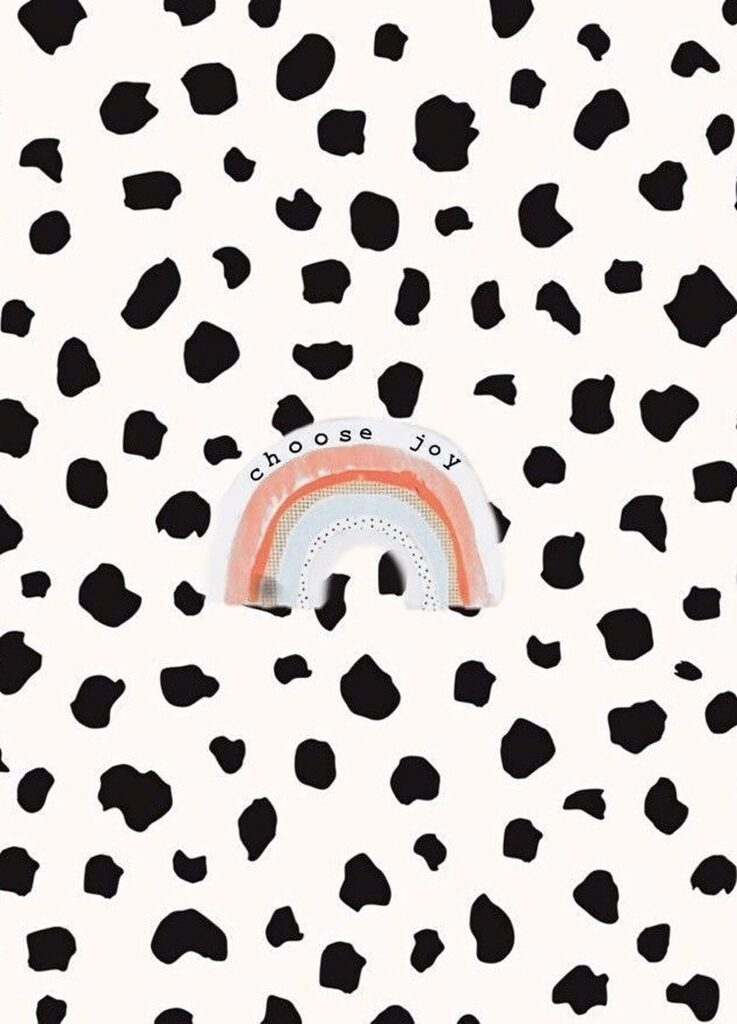 Playful black and white cow print wallpaper with pastel rainbow and choose joy inspirational message
