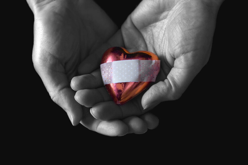 Healing Hearts: 4K Wallpaper of Hands & a Bandaged Heart