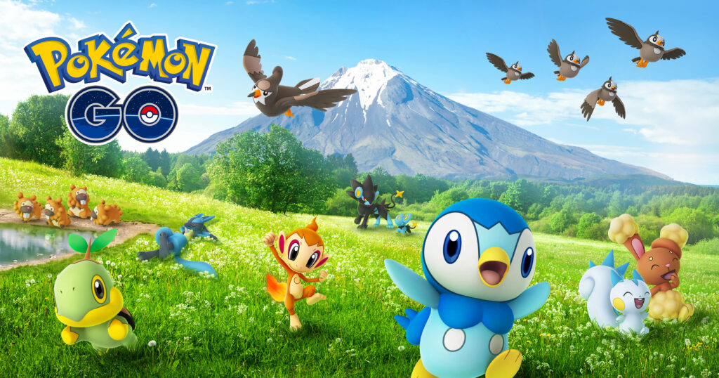 Vibrant Pokémon Go Artwork: Playful Pokémons Traverse Lush Green Landscape beneath Majestic Mountain Wallpaper