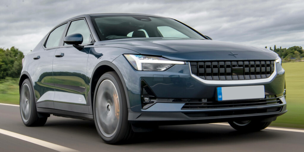 Polestar 2 electric car driving on open road in daylight showcasing modern design and technology Wallpaper