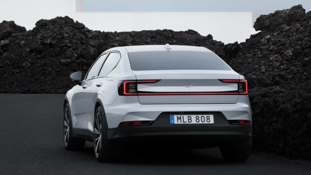 Rear view of Polestar 2 on winding rocky road with sleek design and modern taillights volcanic backdrop Wallpaper