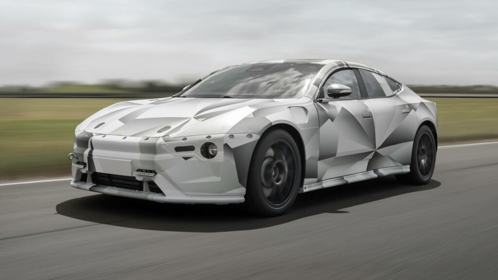 Polestar 5 Prototype driving on open road with futuristic camouflage and sleek modern design Wallpaper