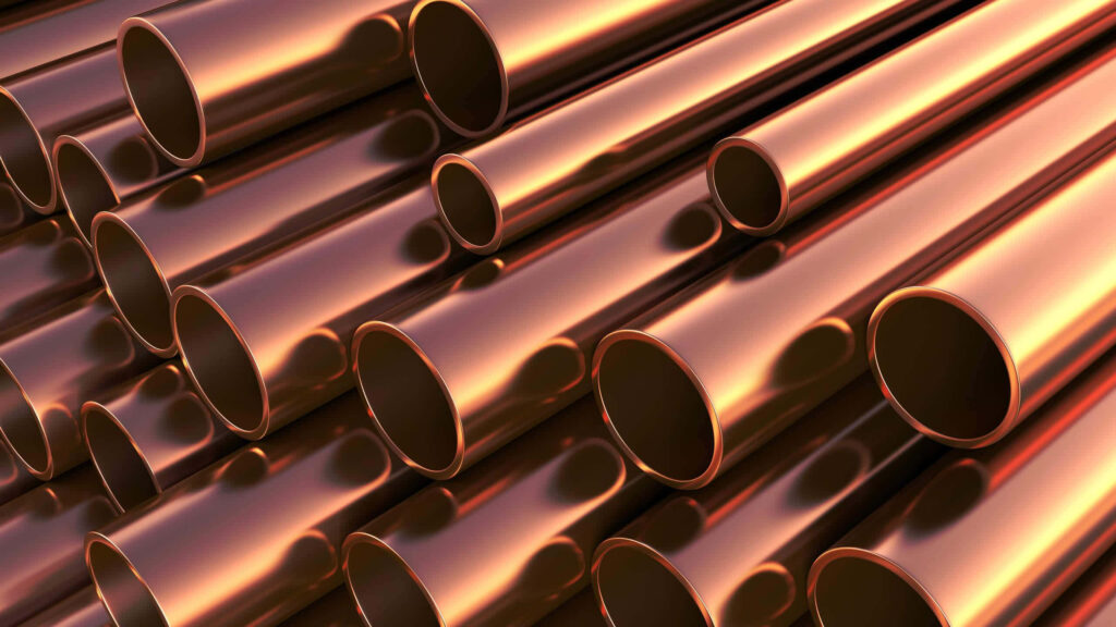 Polished copper pipes with glossy reflections create a warm modern industrial wallpaper background