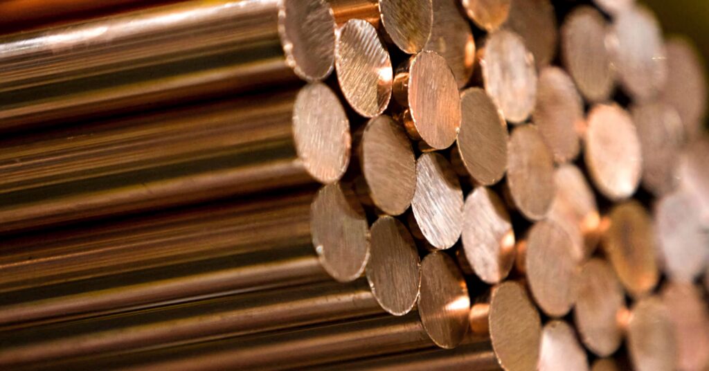 Close-up of polished copper rods with smooth metallic texture and warm reflective tones wallpaper