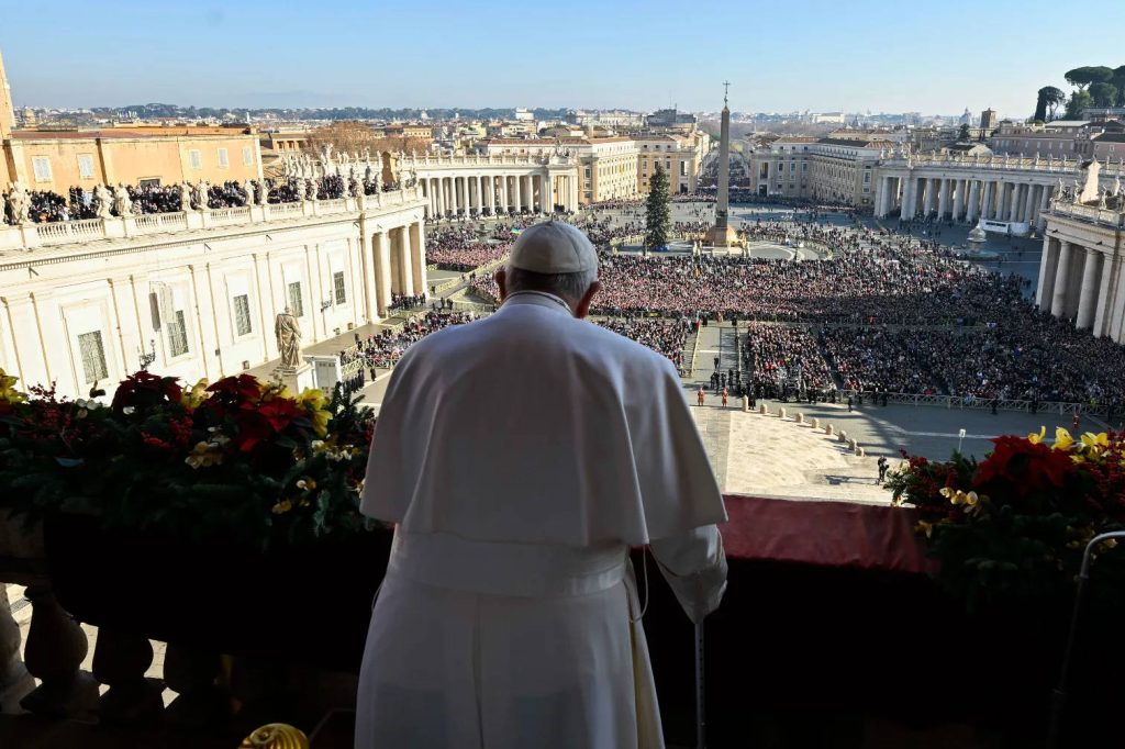 Pope Francis overlooking St Peters Square crowd lit by sunlight with festive poinsettias wallpaper