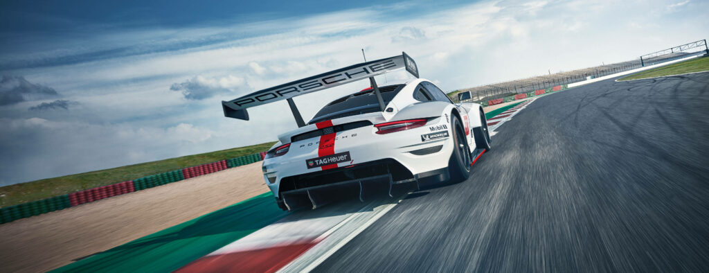 Porsche 911 GT3 RSR speeding on racetrack dynamic wallpaper showcasing sleek racing design