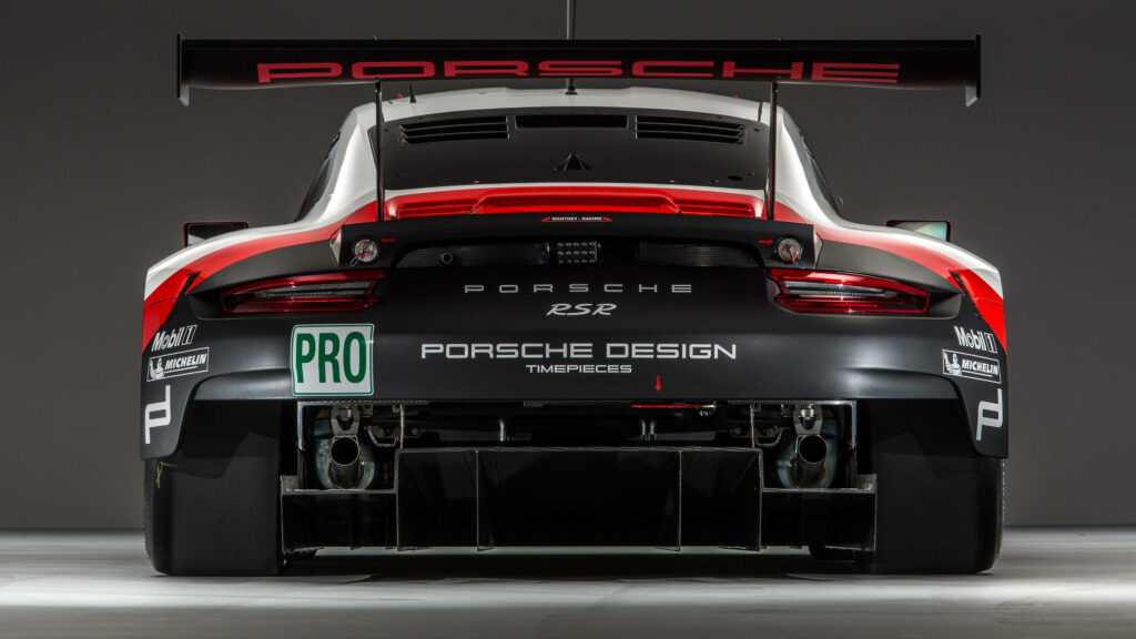 Porsche racing car rear view with aerodynamic design prominent rear wing on sleek background Wallpaper