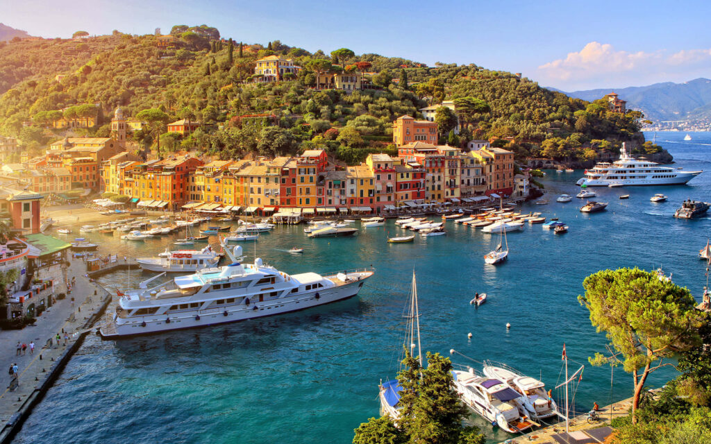 Portofino Italy wallpaper with colorful waterfront buildings yachts and green hillside scenery