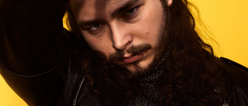 Majestic Melodies: The Musical Charisma of Post Malone in a Striking Background Portrait Wallpaper