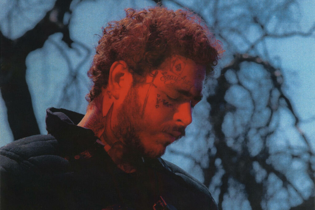 Post Malone Contemplative Wallpaper: Dramatic Leafless Branches Background
