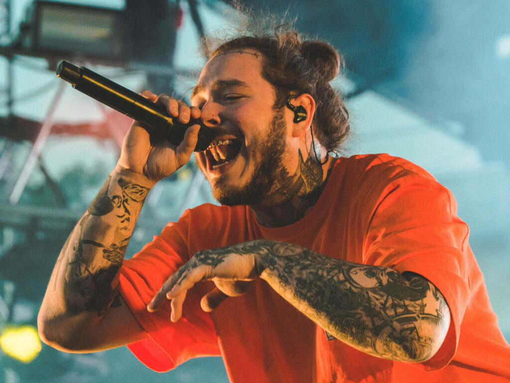 Post Malone Live: Energetic Performance Wallpaper Background