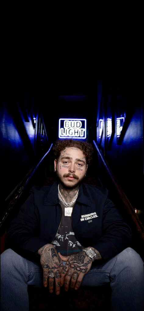 Post Malone Wallpaper: Dimly Lit Scene with Bud Light Sign & Tattoos