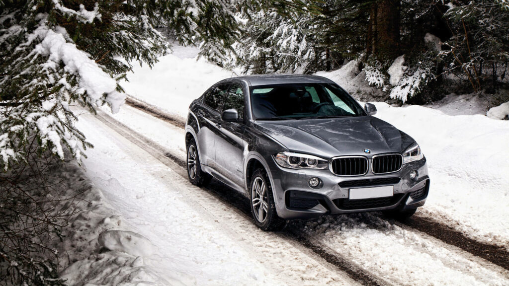Majestic Bmw X6 M Gliding Through Snow-Kissed Forest Path Wallpaper