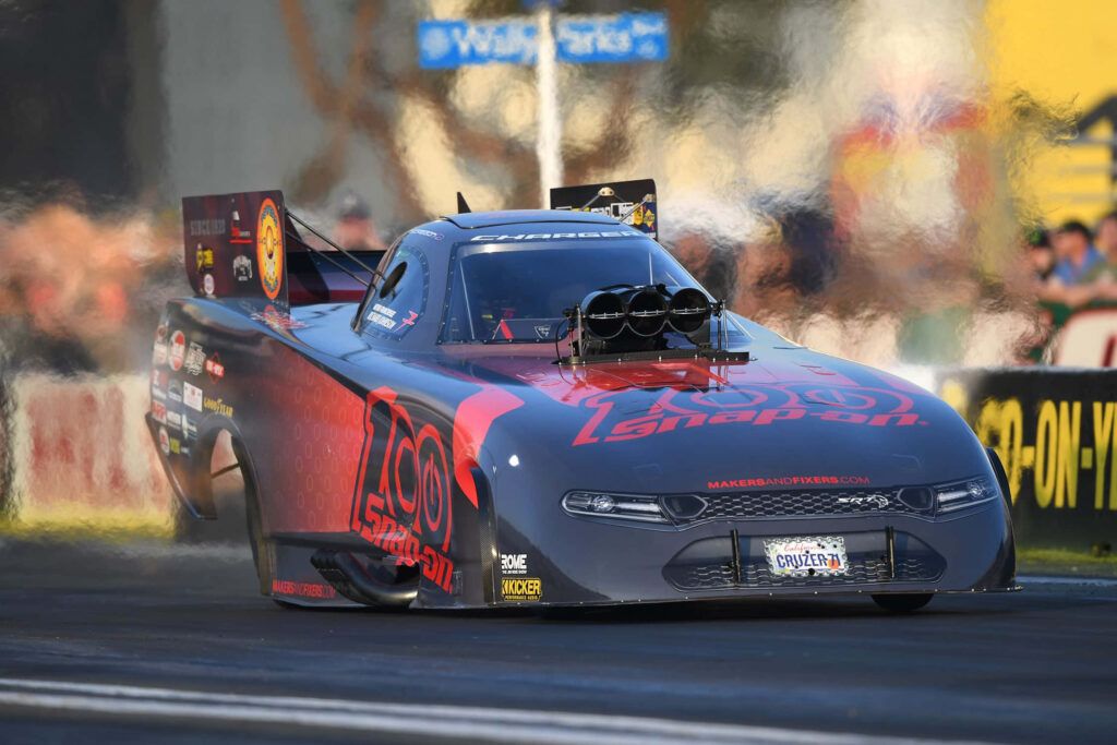Drag racing car speeding on track kicking up smoke thrilling high speed motorsport competition Wallpaper