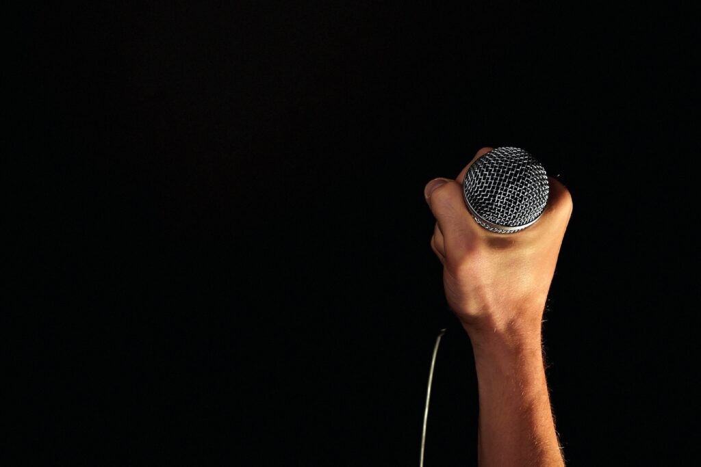 Powerful Mic Grip Wallpaper: Music & Performance Dark Background