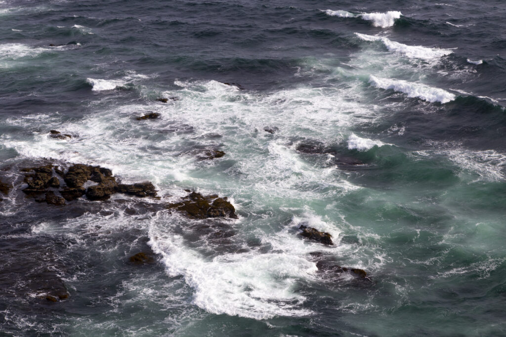 High resolution wallpaper of powerful ocean waves crashing over rocks in deep blue and turquoise colors