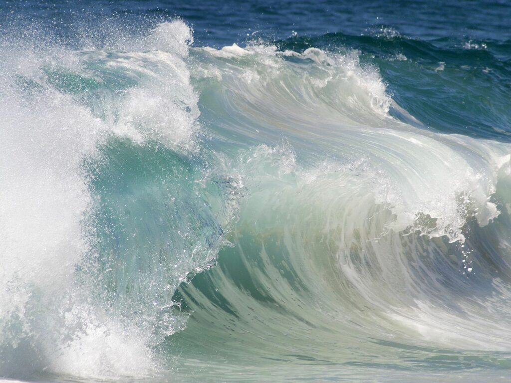 Powerful ocean waves crashing with dynamic motion in deep blue and turquoise wallpaper background
