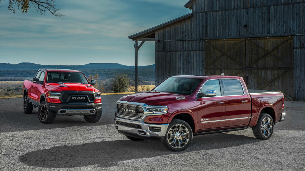 Vibrant Red & Maroon RAM Trucks Wallpaper against Rustic Barn