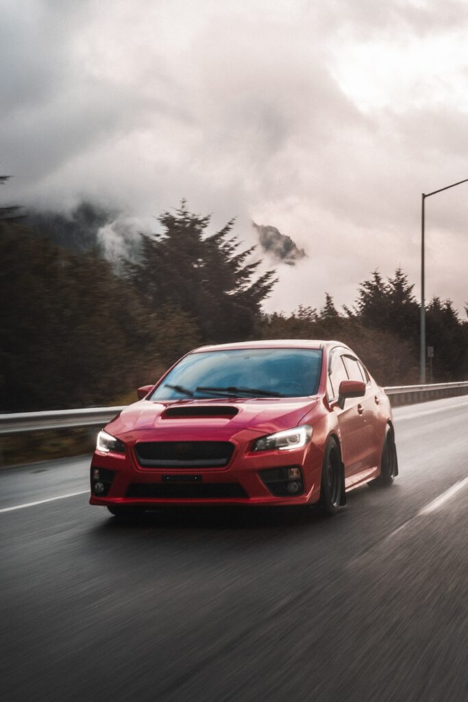 Red Subaru STI in Motion: Dynamic Wallpaper with Misty Trees