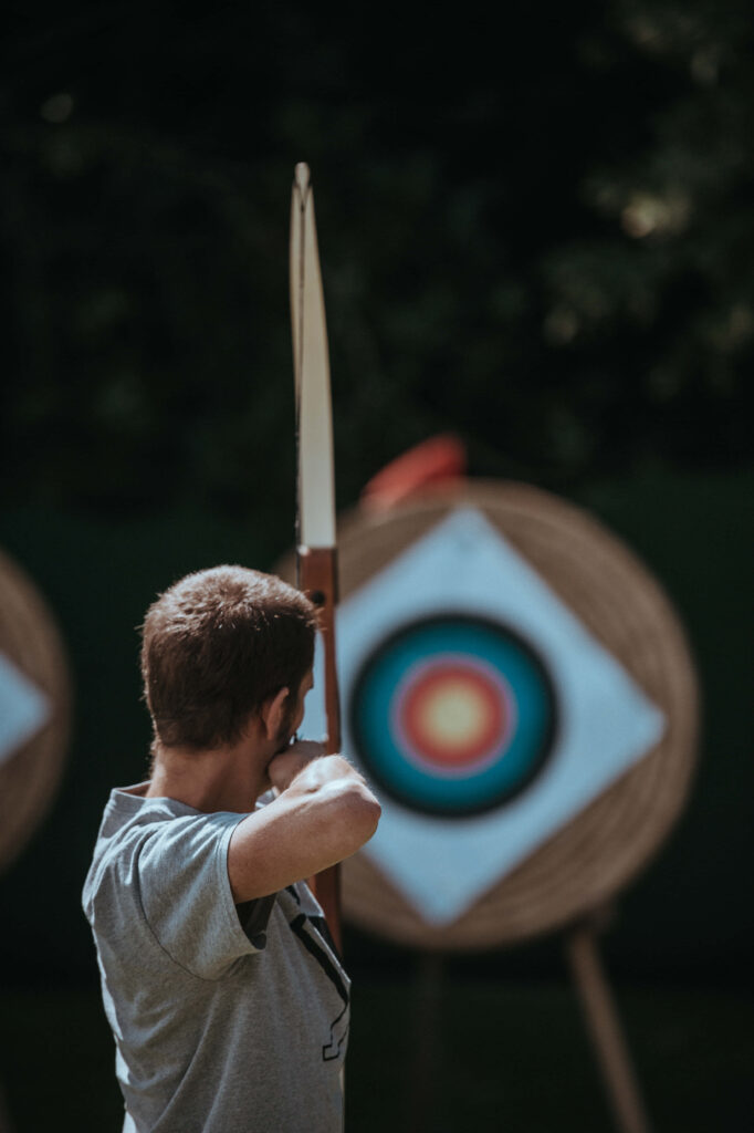 Focused Archer Aiming at Colorful Target - Serene Wallpaper Background