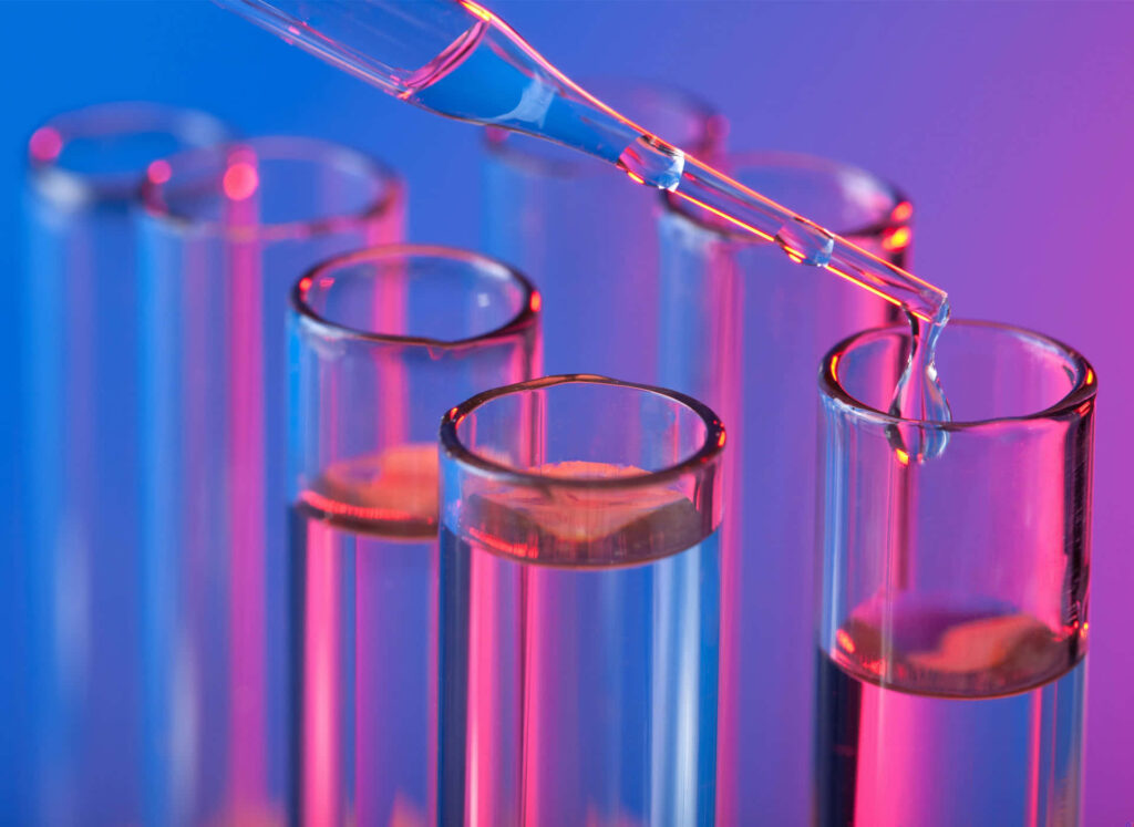 Close-up of glass test tubes filled by dropper with vibrant blue and pink gradient background Wallpaper