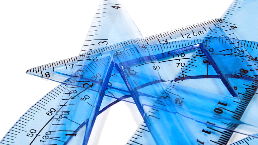 Close-up of transparent blue geometric rulers and protractors on white background for design Wallpaper