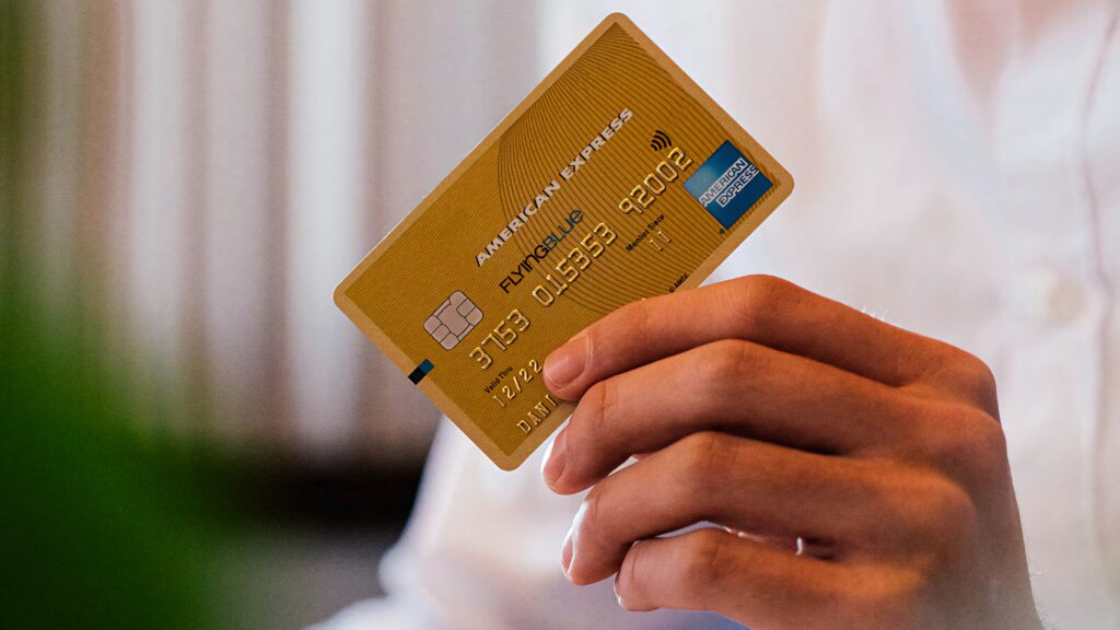 Person holding American Express Flying Blue Gold Credit Card with metallic chip and embossed details Wallpaper