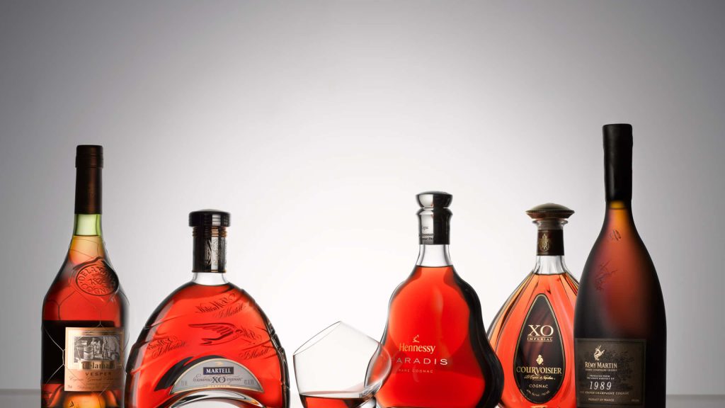 Premium cognac lineup with Delamain Martell Hennessy Paradis Courvoisier Rémy Martin and crystal glass Wallpaper