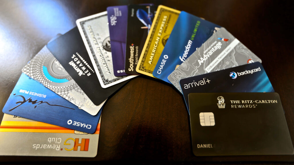 Colorful credit cards from major banks with travel rewards and luxury benefits on dark wood table Wallpaper