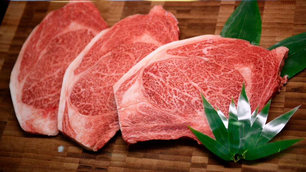Premium Kobe Beef Close-Up: Marble Texture & Green Garnish Wallpaper