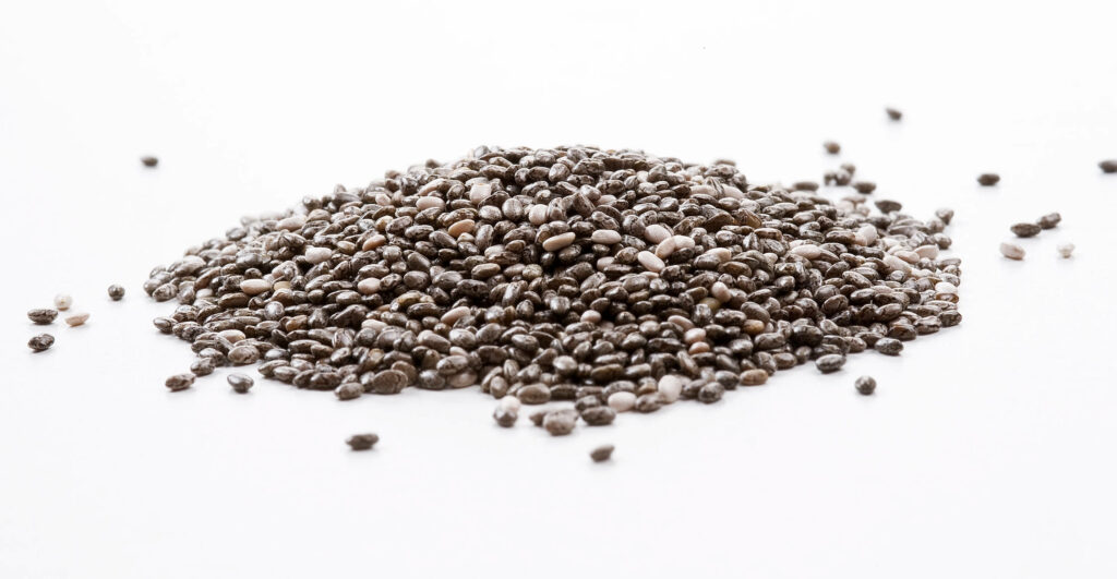 High-resolution chia seeds scattered on white background showcasing natural texture and color Wallpaper