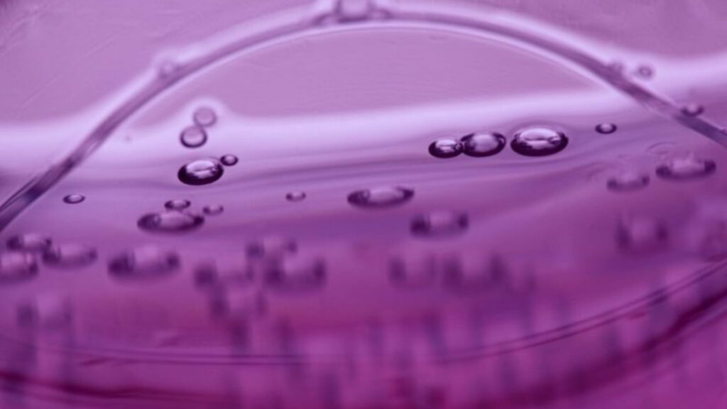 Macro wallpaper of crystalline water droplets on smooth lavender surface with soft lighting