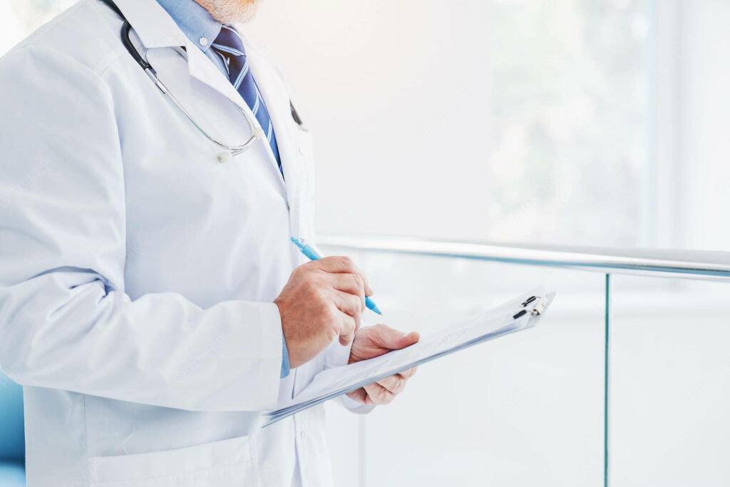 Professional doctor in white coat writing on clipboard in modern clinical healthcare setting Wallpaper