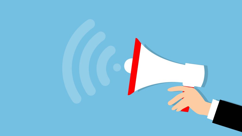 Hand in suit holding megaphone with sound waves on light blue background marketing wallpaper