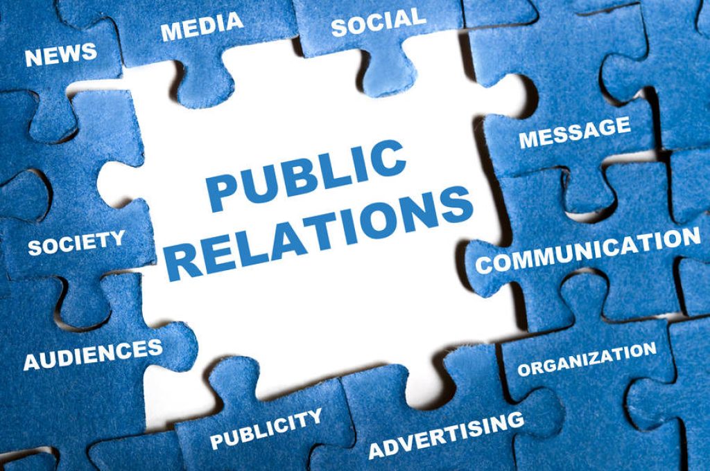 Blue puzzle pieces with PR terms like News Media Social Advertising around Public Relations text Wallpaper