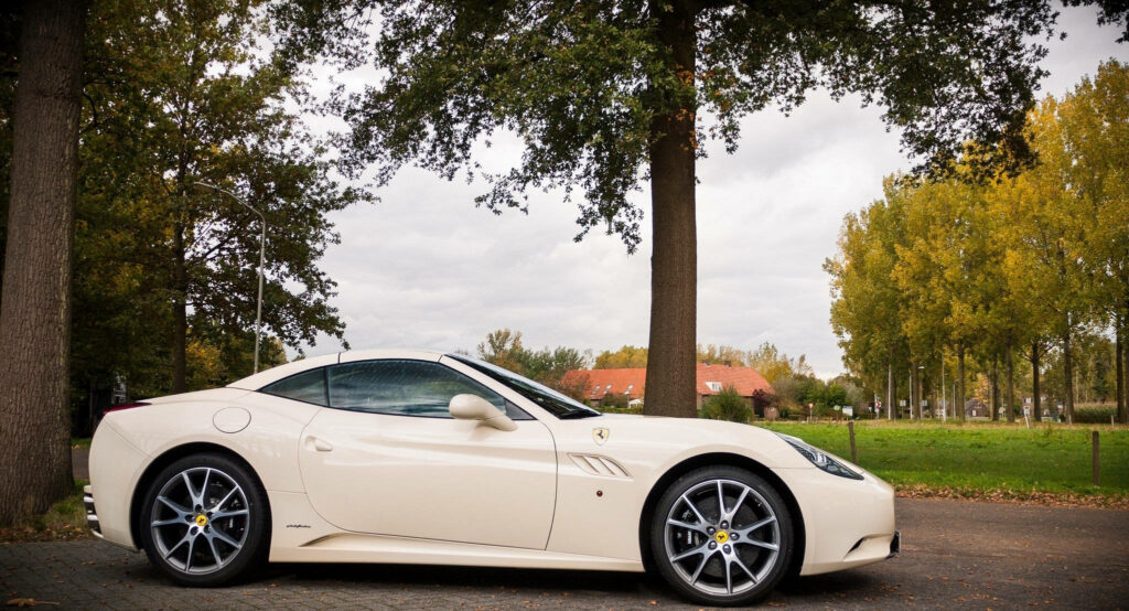Serene White Supercar Resting amidst Tranquil Landscapes: Captivating Ferrari Snapshot Wallpaper
