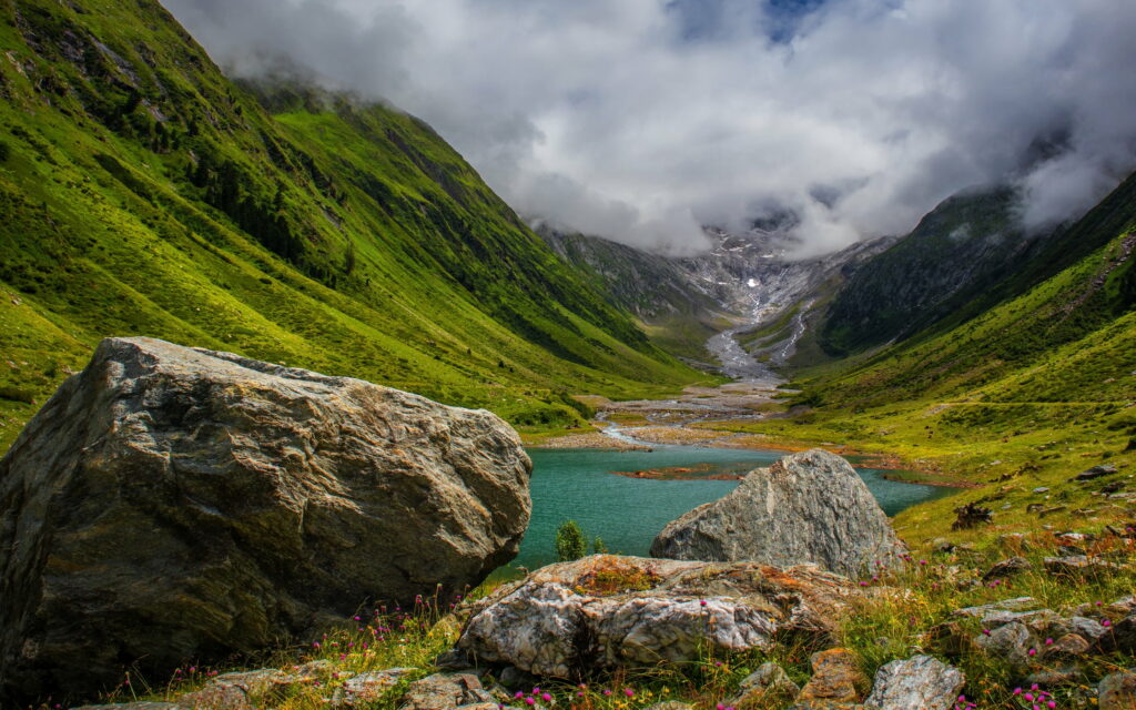 Serene Beauty: Captivating Mountain Valley Landscape with Majestic Glacier, Rocky River, and Dreamy Clouds in Spring - An HD Wallpaper
