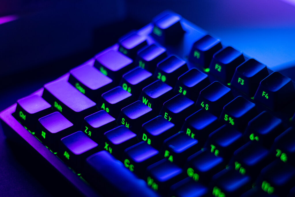 Enchanting Contrasts: Black Gaming Keyboard Illuminated by Purple Aesthetic Lighting Creates an Alluring Background for Gamers Wallpaper