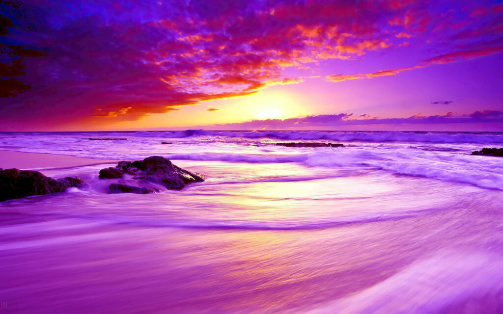 Vibrant purple and magenta sunset over calm sea with golden light and dark coastal rocks wallpaper